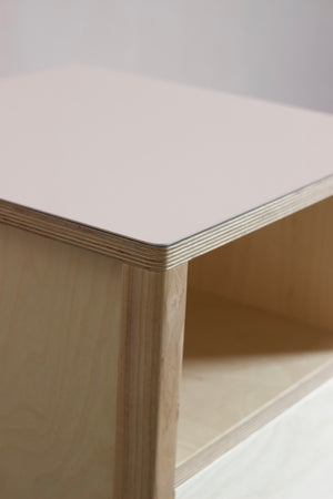 The Huxley bedside table in birch plywood, featuring solid ash legs and Forbo linoleum plywood top. Designed and made by Jon Grant London in Leyton, East London.