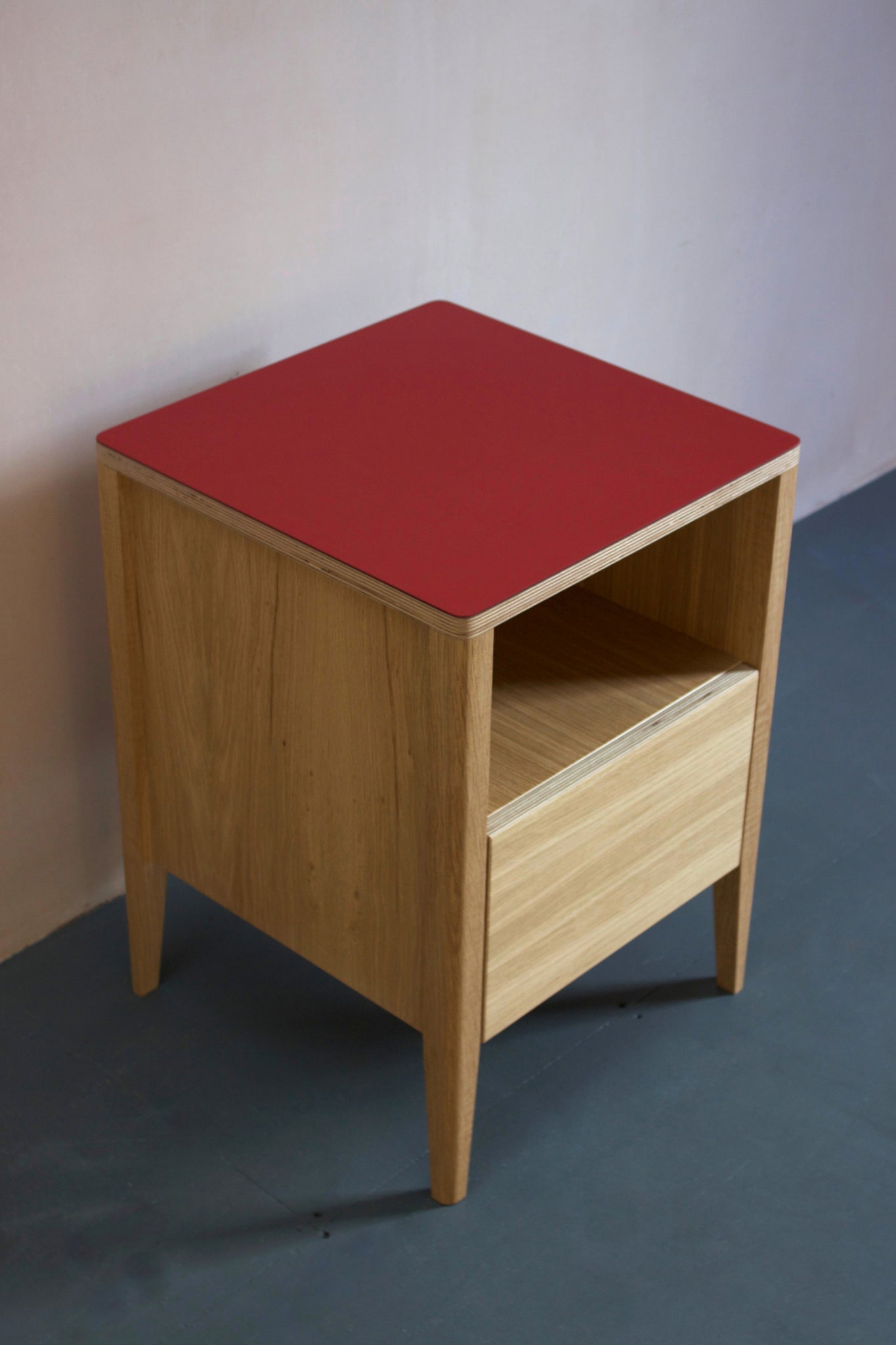 Handmade bedside table, perfect for a modern home. It features Forbo linoleum top with oak veneered plywood carcasses and solid oak legs. Designed & made by Jon Grant London in Leyton, East London.